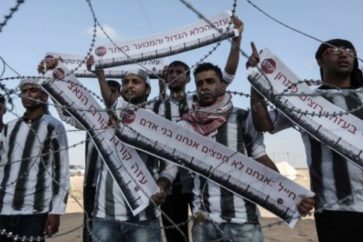 De jeunes Palestiniens manifestent à la frontière de Gaza en arborant des banderoles qui disent en hébreu : « Soldat, nous ne sommes pas des objets, nous sommes des êtres humains »