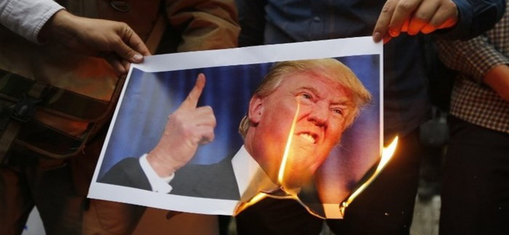 Iranians burn an image of US President Donald Trump during an anti-US demonstration outside the former US embassy headquarters in the capital Tehran on May 9, 2018.
Iranians reacted with a mix of sadness, resignation and defiance on May 9 to US President Donald Trump's withdrawal from the nuclear deal, with sharp divisions among officials on how best to respond.
For many, Trump's decision on Tuesday to pull out of the landmark nuclear deal marked the final death knell for the hope created when it was signed in 2015 that Iran might finally escape decades of isolation and US hostility.  / AFP PHOTO / ATTA KENARE