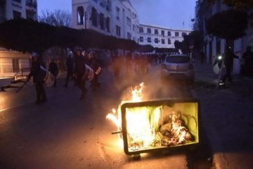 Members of the Algerian security forces patrolling a street in the capital Algiers, walk past a garbage container set ablaze by protesters during a demonstration against Algeria's president's candidacy for a fifth term, on February 22, 2019. - Clashes broke out in the Algerian capital today between security forces and demonstrators opposed to a bid by ailing President Abdelaziz Bouteflika to run for a fifth term, AFP correspondents said.
Police in riot gear fired tear gas and set up a security cordon to block access to the presidential palace by demonstrators who responded with stone-throwing. (Photo by RYAD KRAMDI / AFP)