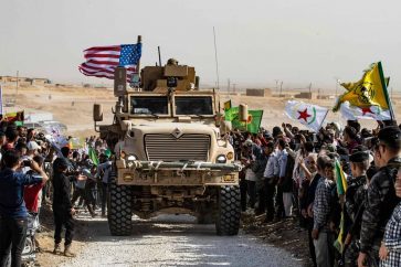TOPSHOT - Syrian Kurds gather around a US armoured vehicle during a demonstration against Turkish threats next to a US-led international coalition base on the outskirts of Ras al-Ain town in Syria's Hasakeh province near the Turkish border on October 6, 2019.
Ankara had reiterated on October 5 an oft-repeated threat to launch an "air and ground" operation in Syria against a Kurdish militia it deems a terrorist group. / AFP / Delil SOULEIMAN