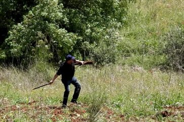 Un des habitants d'Aytaroun arrache un poteau israélien