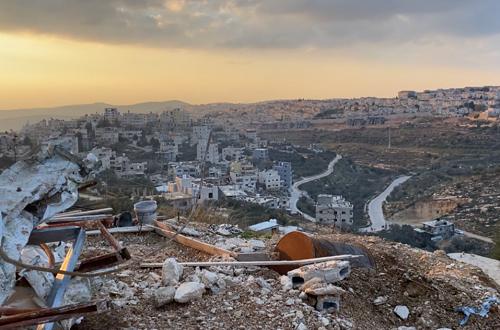 La maison d'une famille palestinienne qui a été détruite et par derrière une colonie israélienne édifiée sur les territoires de la localité de Nahaline en Cisjordanie occupée (Al-Jazeera)