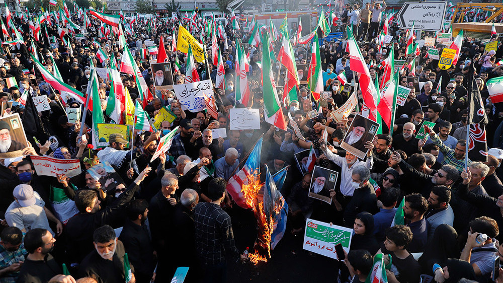 Des manifestants iraniens brulent les drapeaux israéliens et américains le 25 septembre 2022.