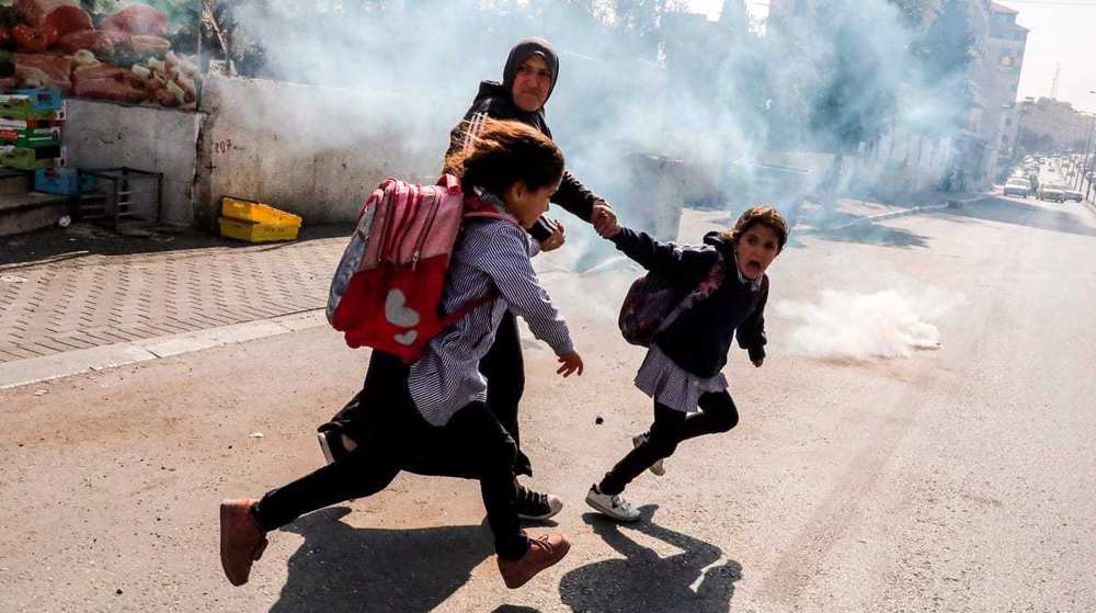 Une femme et deux écolières tentent de fuir les gaz lacrymogènes tirés par les forces israéliennes en Cisjordanie, le 17 novembre 2019. ©Getty Images
