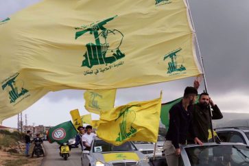 Des sympathisants du Hezbollah agitent le drapeau du parti sur une autoroute à Marjayoun, au sud-Liban. ©Reuters