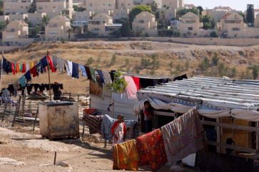 Des enfants palestiniens jouent devant leur maison dans la ville d'al-Eizariya proche de la colonie Maale Adumim en arrière-plan, en Cisjordanie occupée par ‘Israël’. ©Reuters